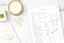 A self-care notepad on a white table next to a candle and gold accessories.