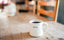 A mug of coffee sits on a wooden table