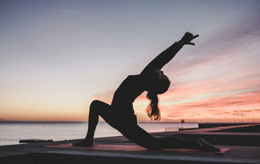 a silhouette of a person doing yoga in front of a sunset