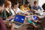 A table full of people in a meeting looking at computers