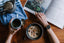 Person holding coffee cup and flipping through magazine