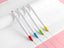 Colorful pens on white paper on a pink background