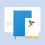 Blue notebook with a calendar featuring a green bird illustration on a light blue background