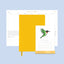 Yellow planner with a calendar featuring a green bird illustration on a light blue background