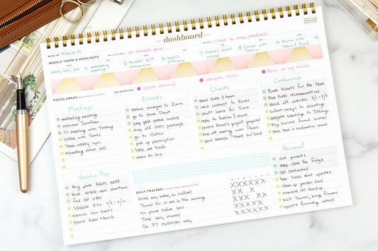 A dashboard deskpad filled in with handwriting and decorated with light colored washi tape
