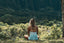 A woman sits in a sunny field