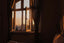 An open window with evening night shining into a dark room