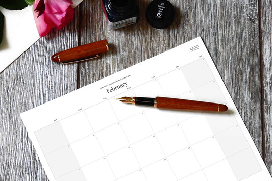 A 2023 calendar on a desk with a red pen