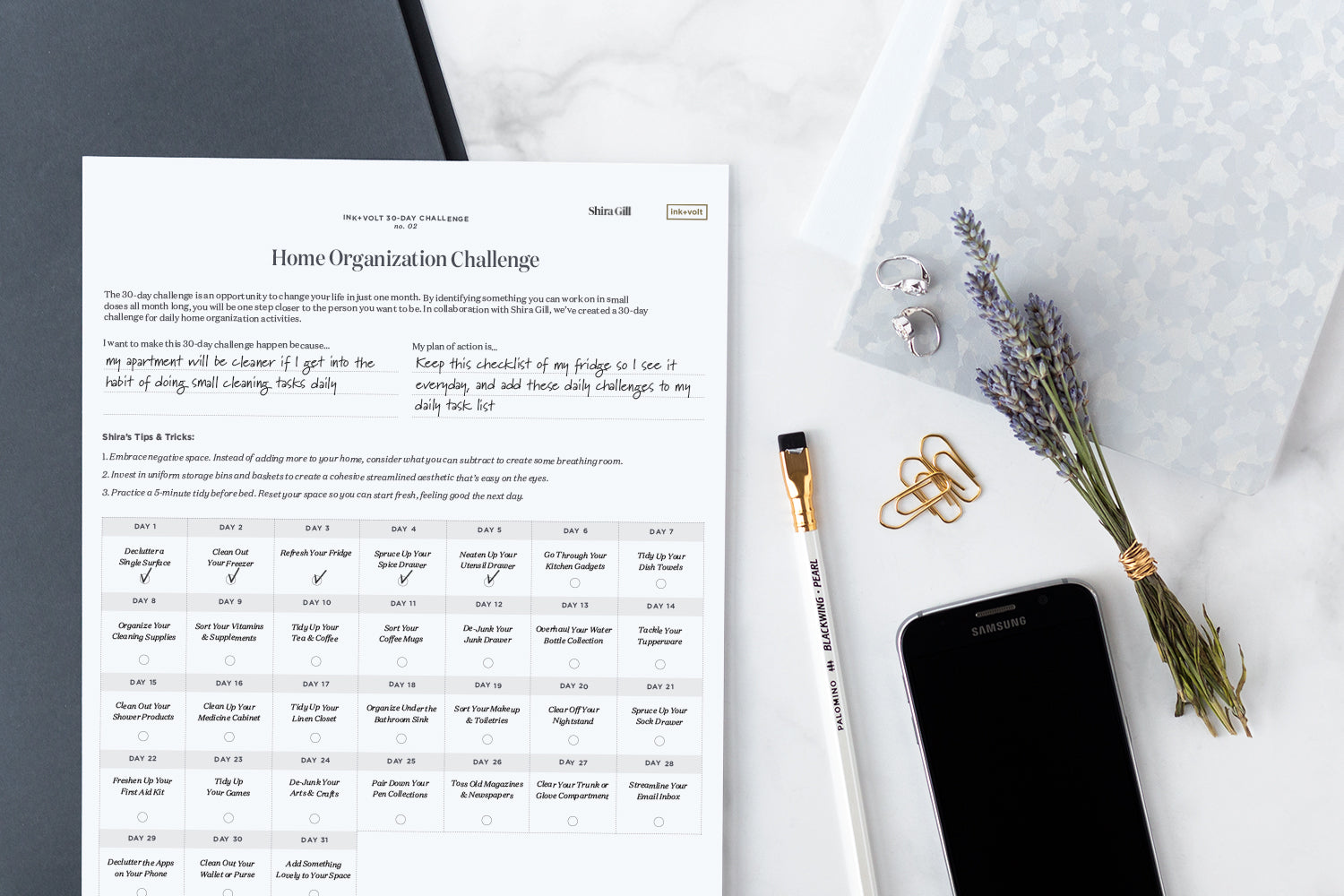 Shira Gill's 30 day challenge worksheet sits on a beautiful organized desk.