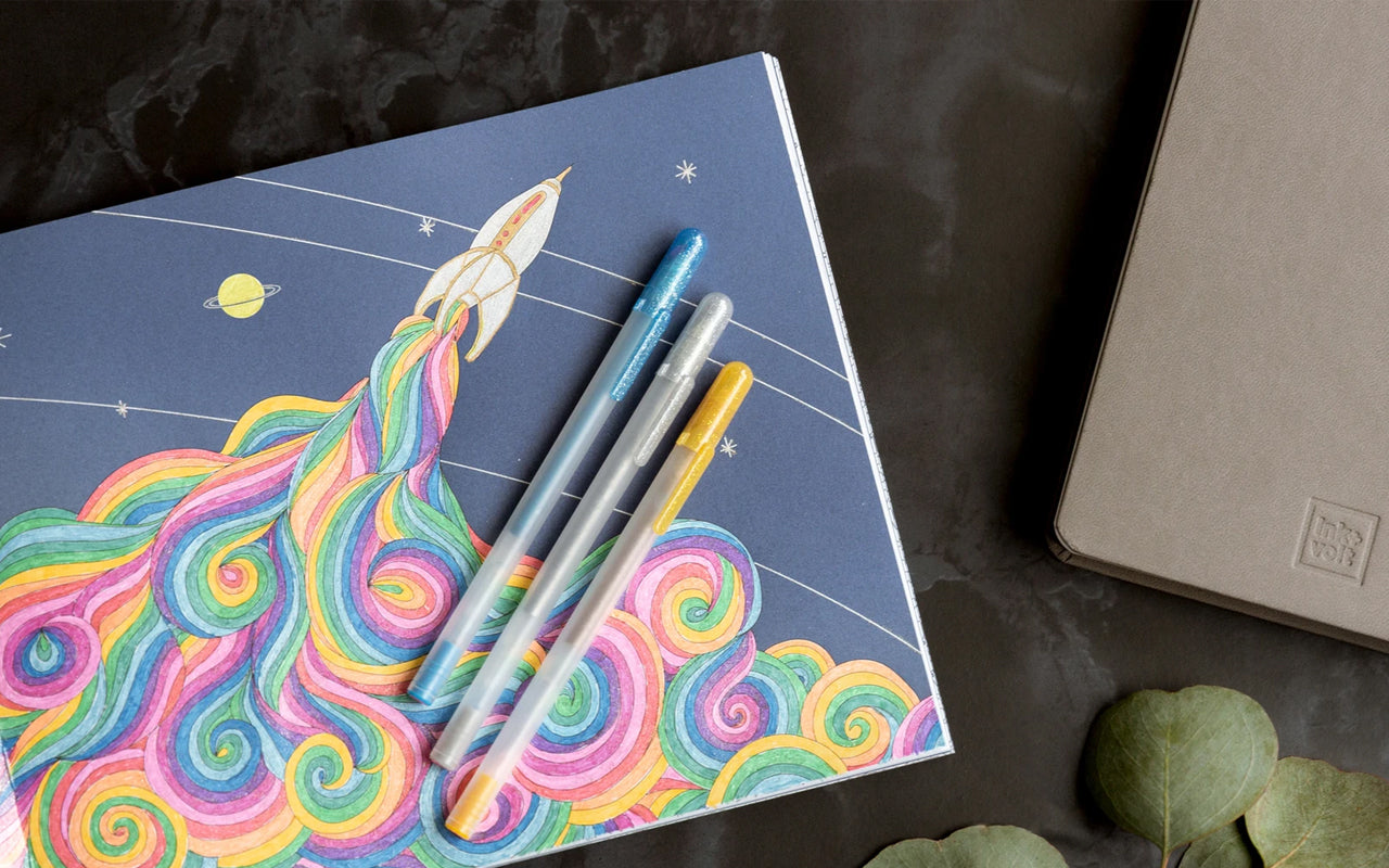 A brightly colored coloring page showing a rocket blasting off, with three gel pens laying on top.