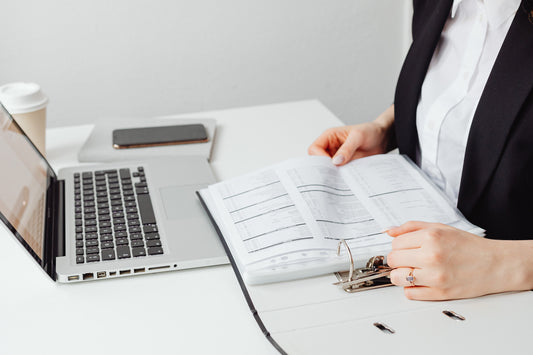 person placing papers into a ring binder