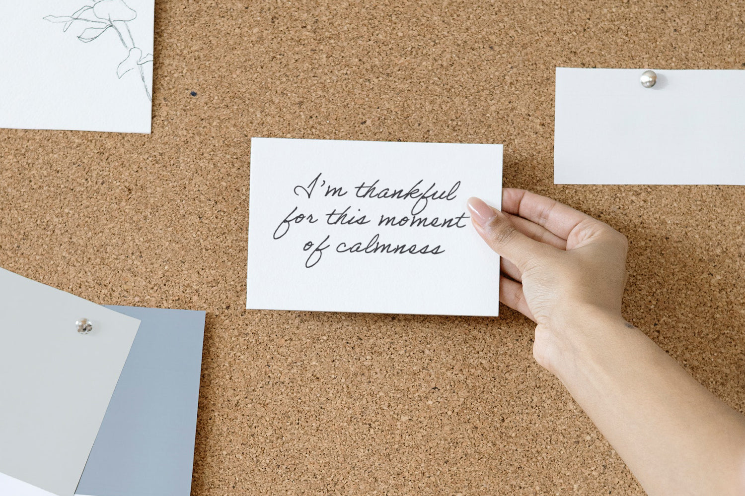 person holding an affirmation in front of a corkboard