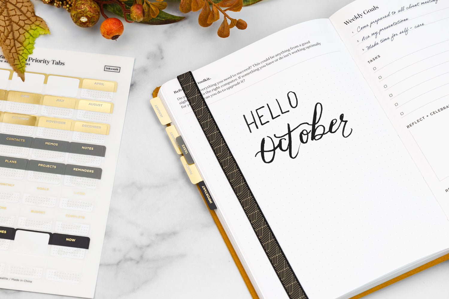 A planner with the words "hello october" written in calligraphy