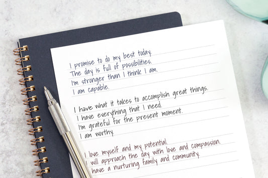 A hand-written list of morning affirmations on white notebook paper.