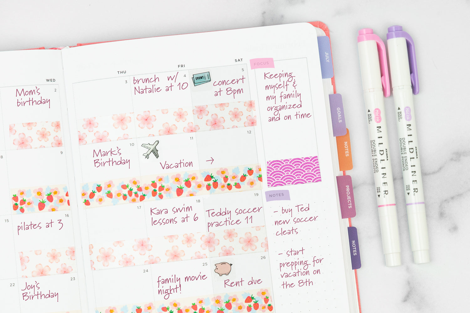 A planner calendar page filled out with pink ink and colorful washi tape