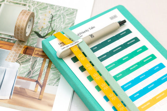 A planner with colorful accessories including washi tape, book bands, and planner tabs.