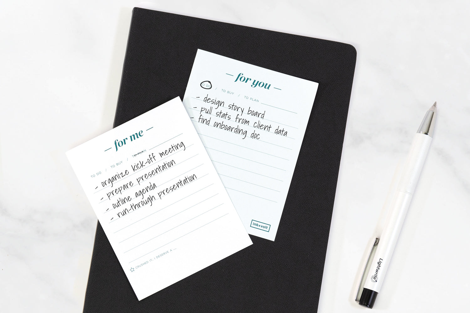 A for me/for you time management tool notepad with lists of tasks for two people, sitting on a black planner