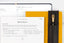a mid-year review worksheet, partially filled out, on top of a yellow planner with a black pencil holder