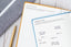 Two planners sit on a table, open to productivity and planning pages