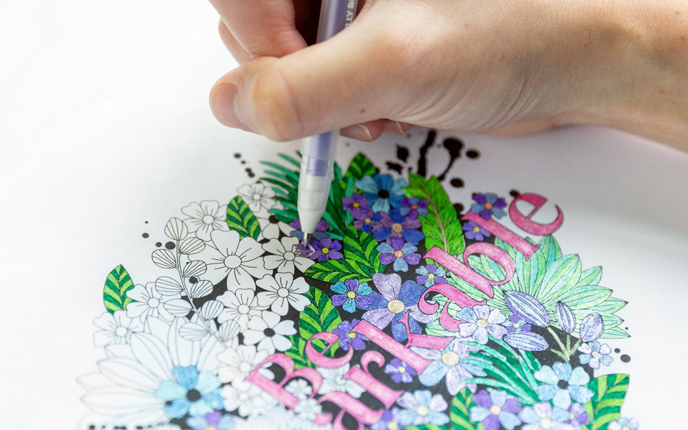 Someone is coloring in a floral coloring page with the words "Be Remarkable."