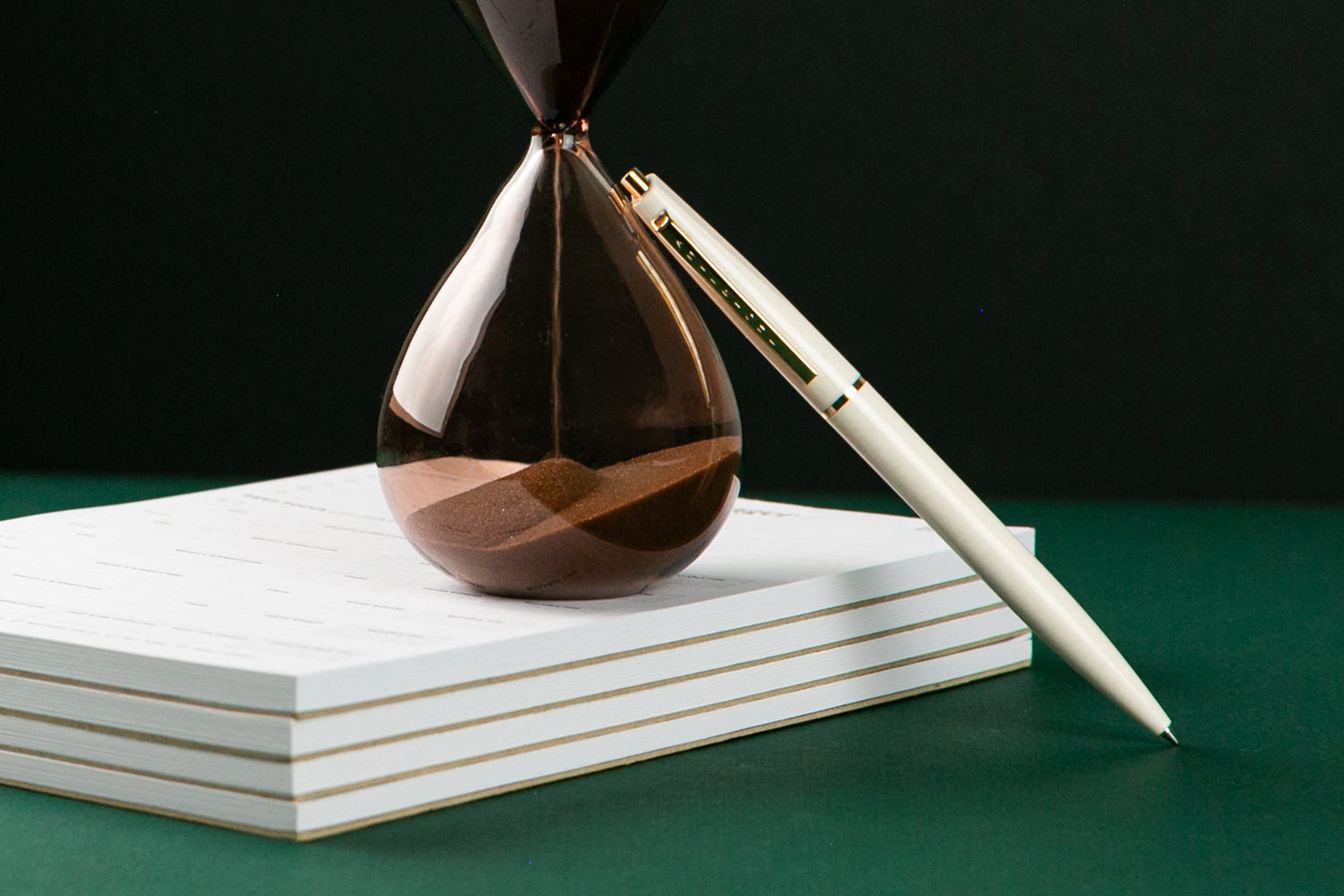 A planner sits open to a calendar page on a gold silky sheet.