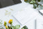 A desk with flowers, gold paperclips, and a time management matrix notepad.