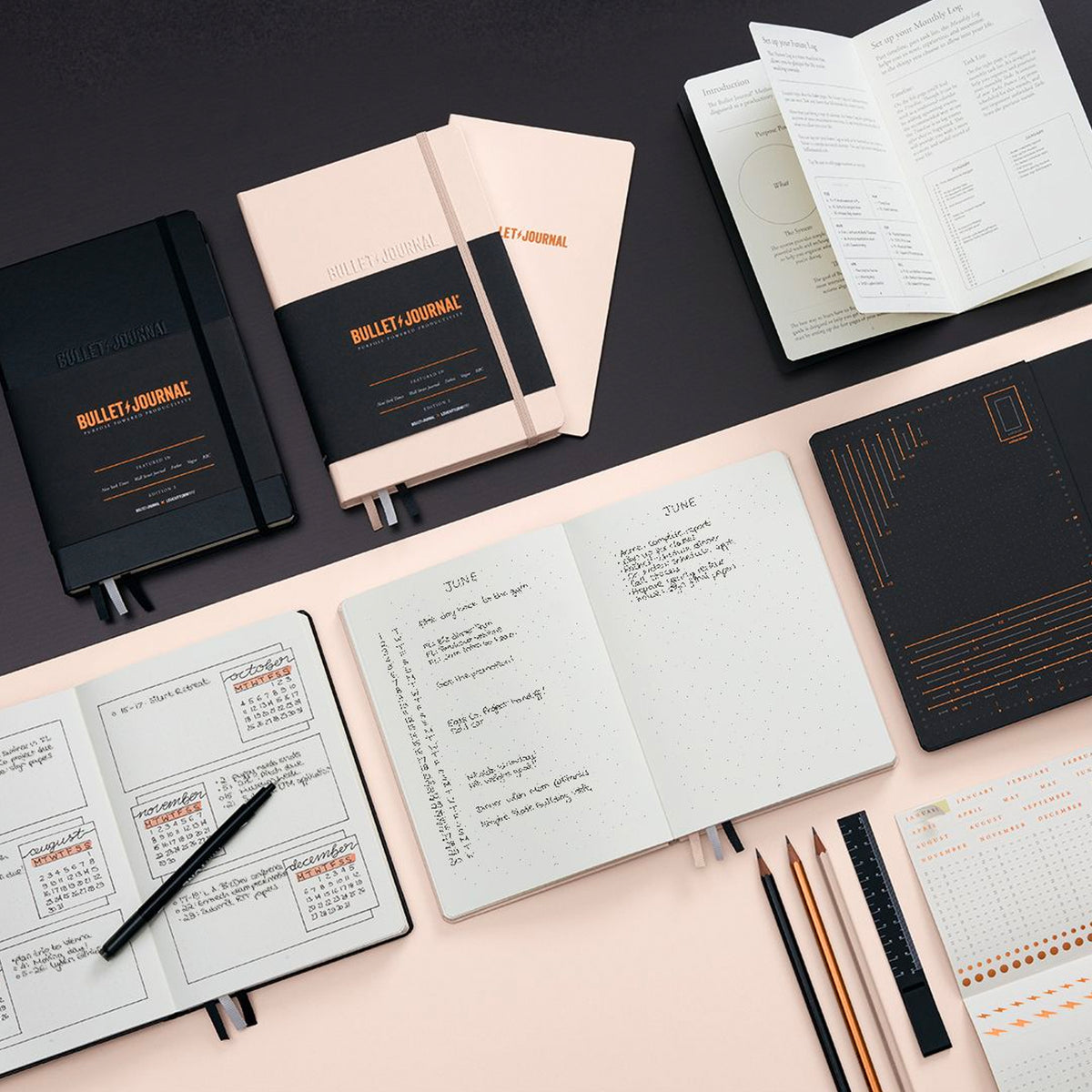 An array of black and pink notebooks and planning tools