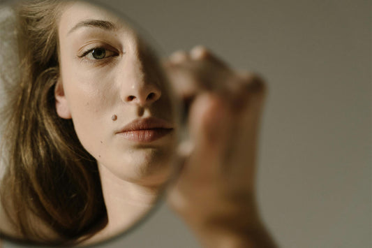 A woman looks into a mirror