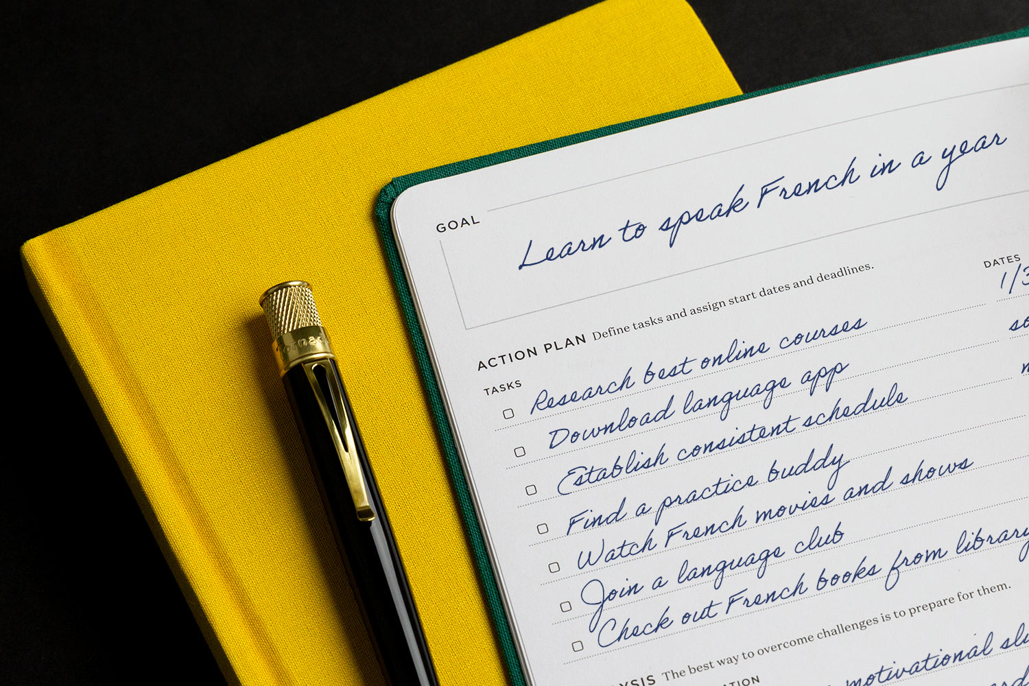 A yellow planner, black pen, and an open planner with writing on the pages