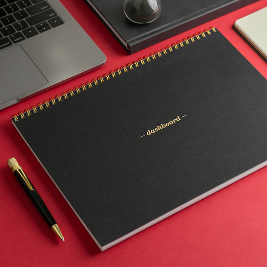 A black dashboard deskpad sitting on a red table