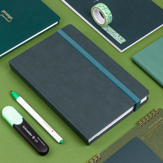 An assortment of planners and planning tools on a green background