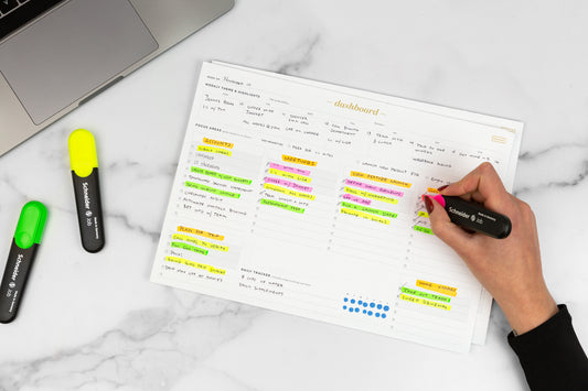 A full schedule written on a dashboard productivity pad with bright highlighters