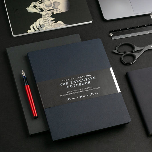 An executive notebook and other dark desk accessories