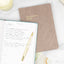 a daily reflection journal filled out with lessons, on top of another journal on a white table