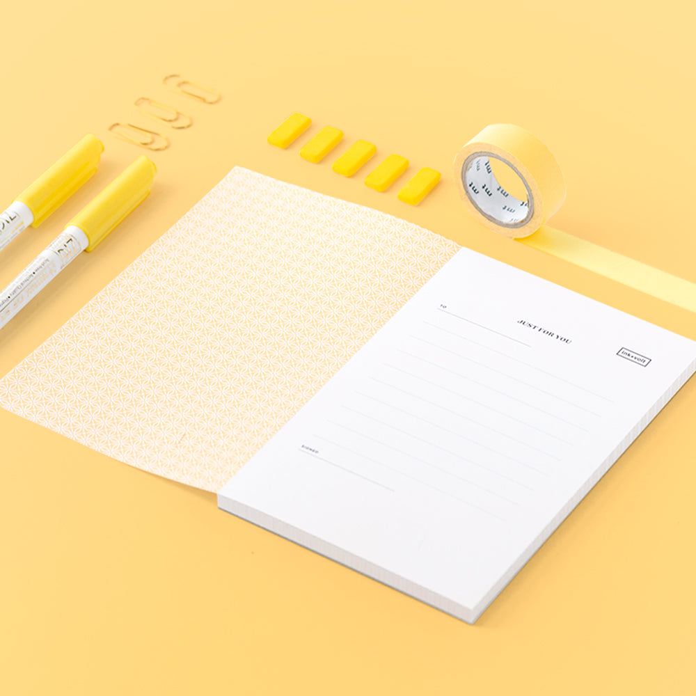 A bright yellow collection of desk accessories including markers, tape, and a special notepad.