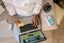 A person with a laptop on their lap holding a credit card