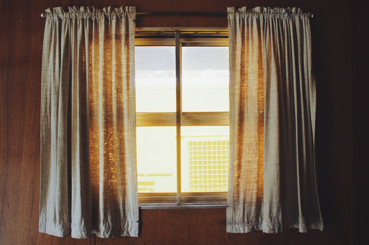 A window with white curtains and light shining through