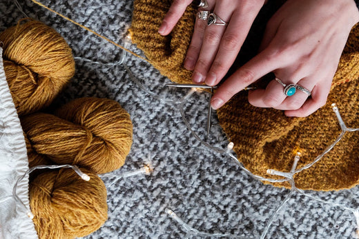 Two hands working on grey and brown knitting yarn