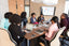 Women sit around a meeting table with computers