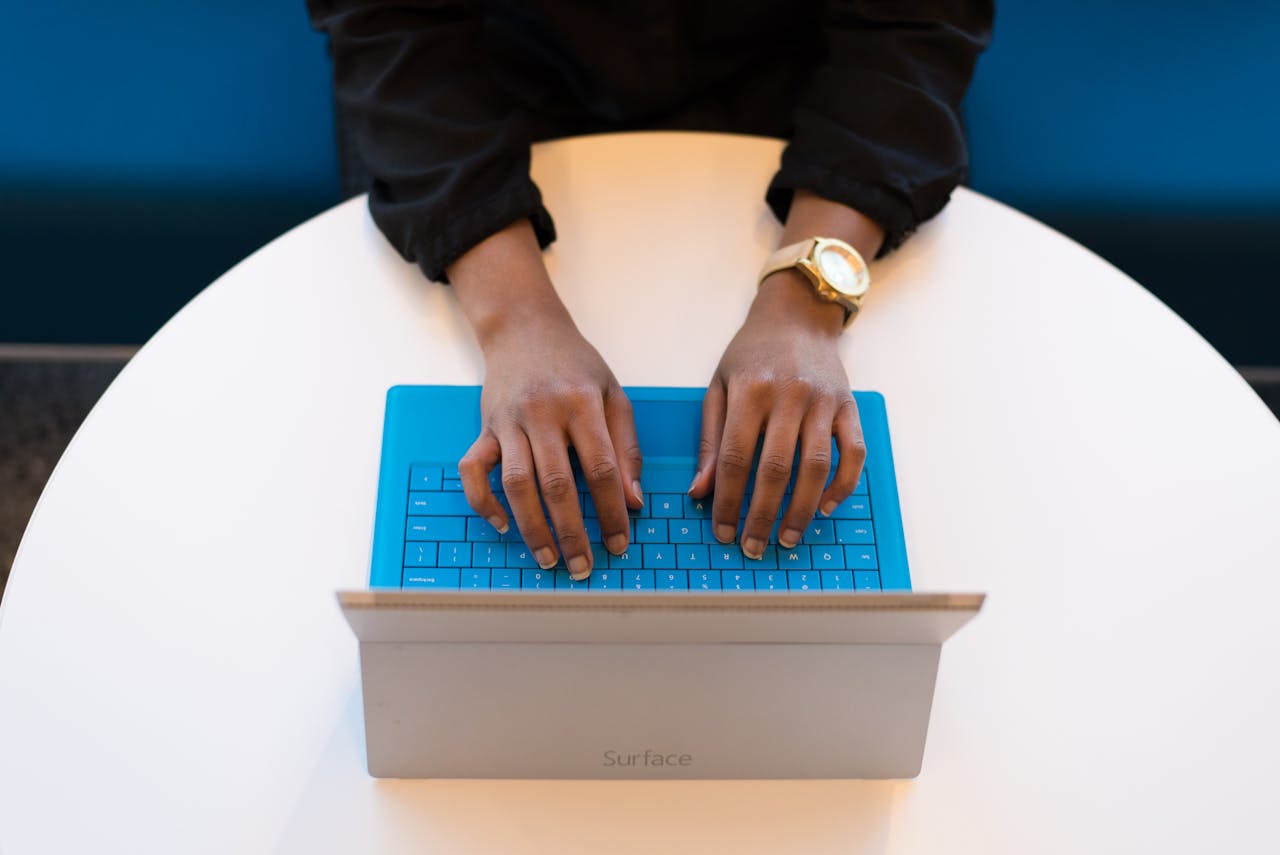 Hands typing on a blue tablet keyboard