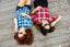 Two friends in sunglasses lie on their backs outside smiling