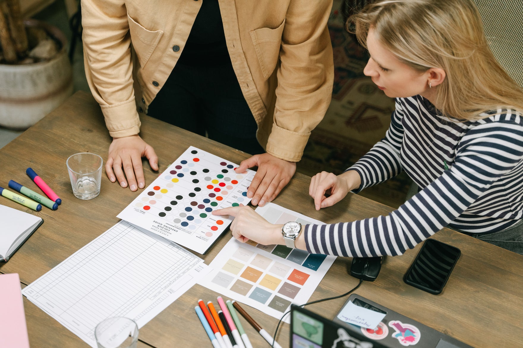 three people gathered around a table discussing color palettes