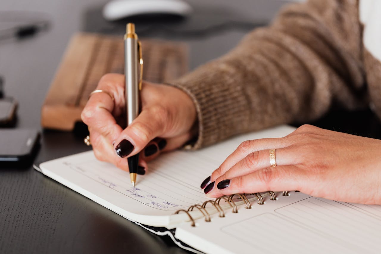 A woman's hand writing on notebook paper