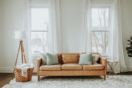 A large, airy living room with a comfortable light brown couch.