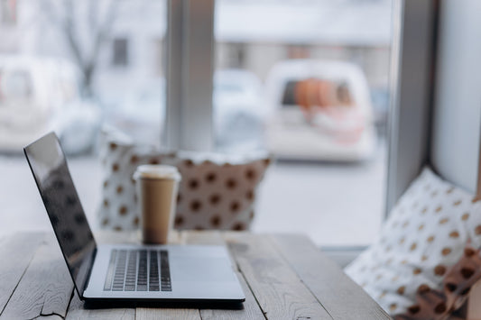 A laptop on a table in front of a window