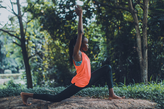 A woman doing a yoga pose in front of trees