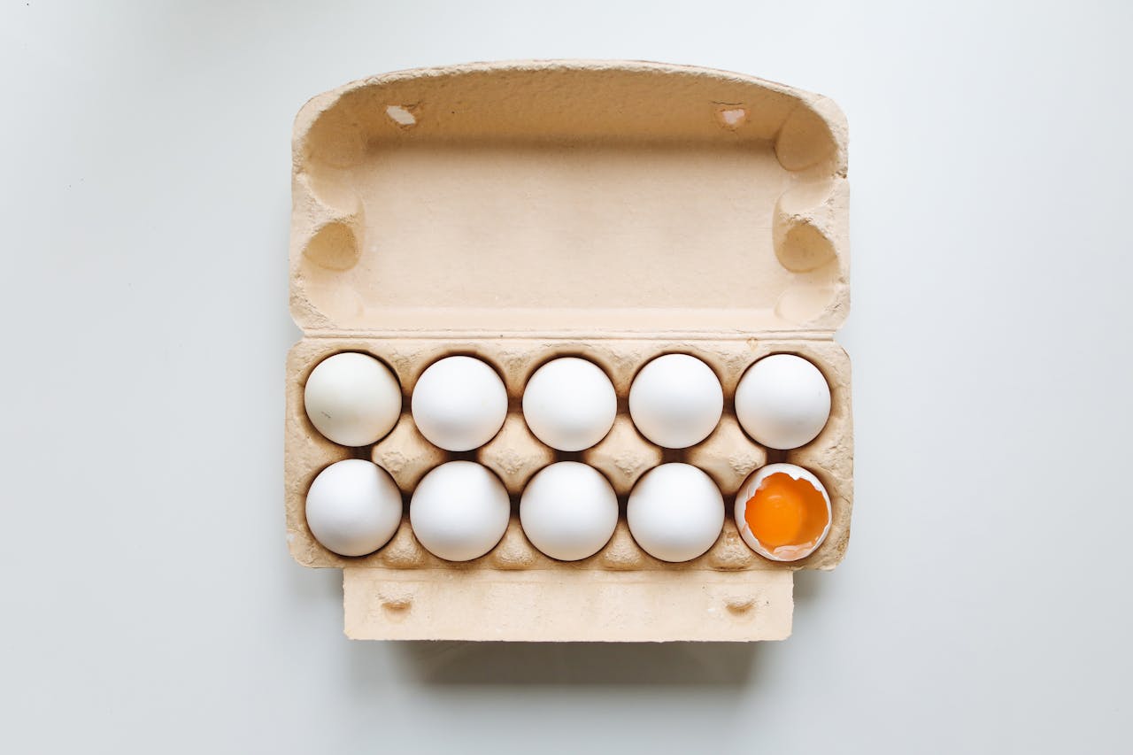 A box of eggs with one broken one