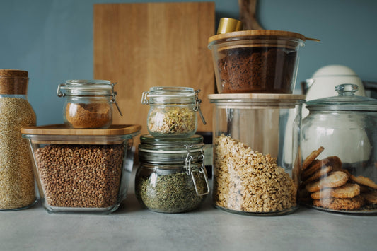 An array of glass jars with dried goods inside on a white countertop