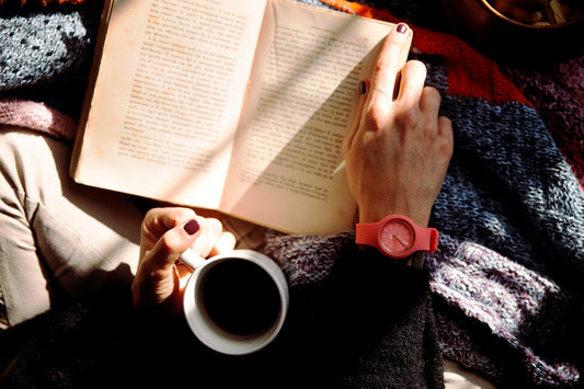 A book and a cup of coffee in a person's lap