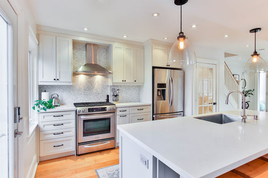 A clean kitchen with white countertops and cupboards